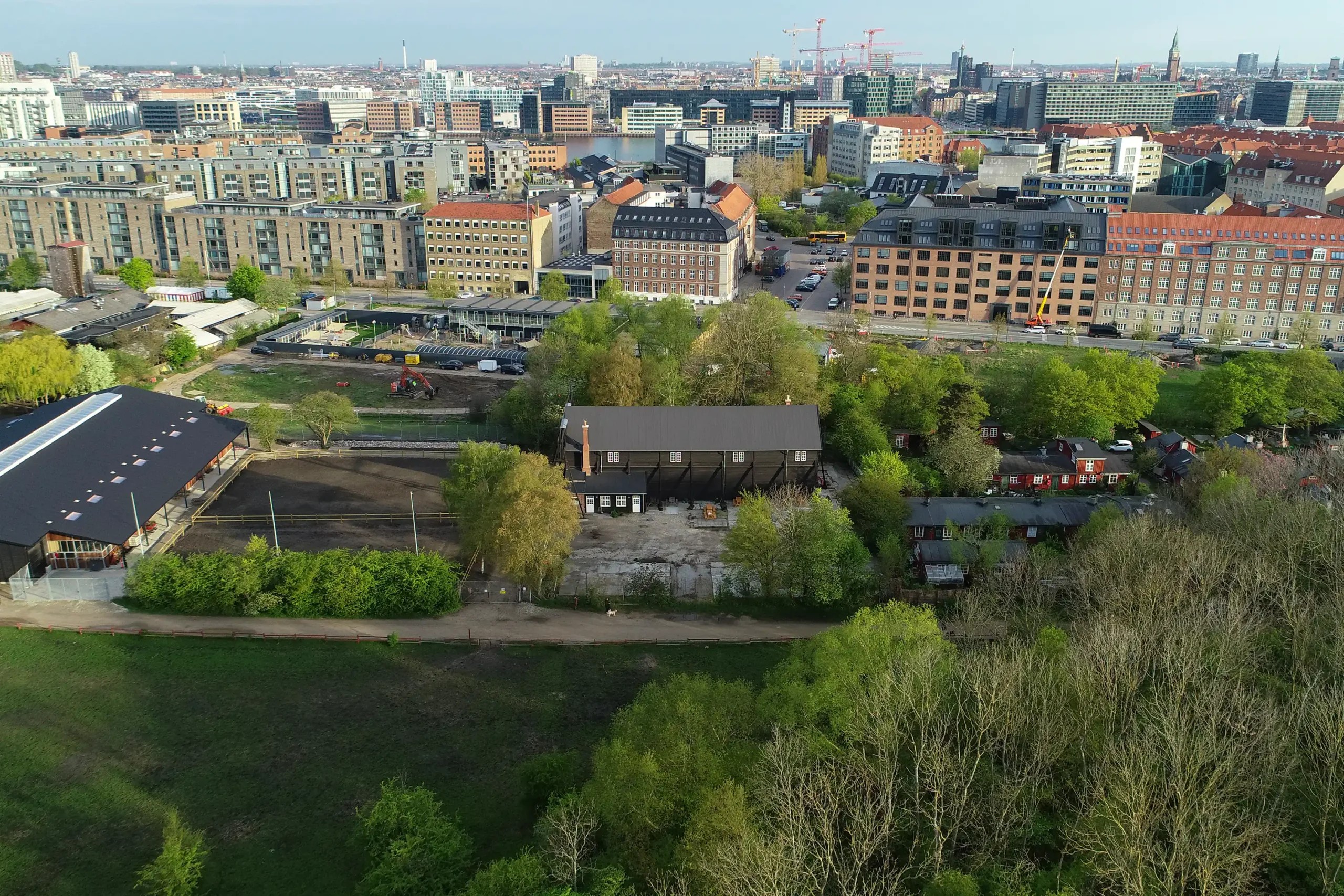 Dronevideo og dronefotos taget af København, hvor man både ser grønt areal og storbyen med huse og bygninger.